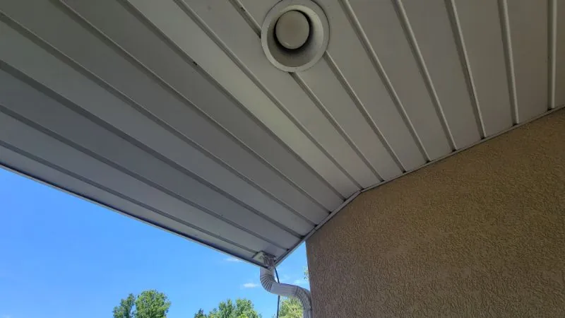 Round soffit vent installed under a finished eave