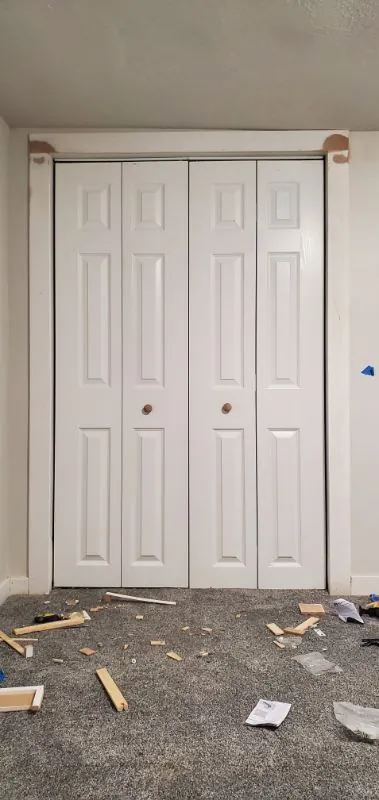 White bi-fold closet doors hung in a bedroom