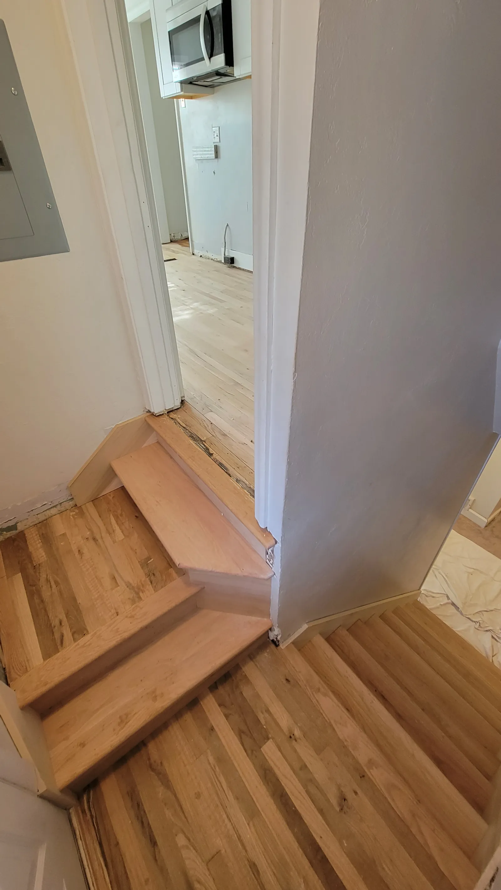 Wood stair treads meeting new plank flooring
