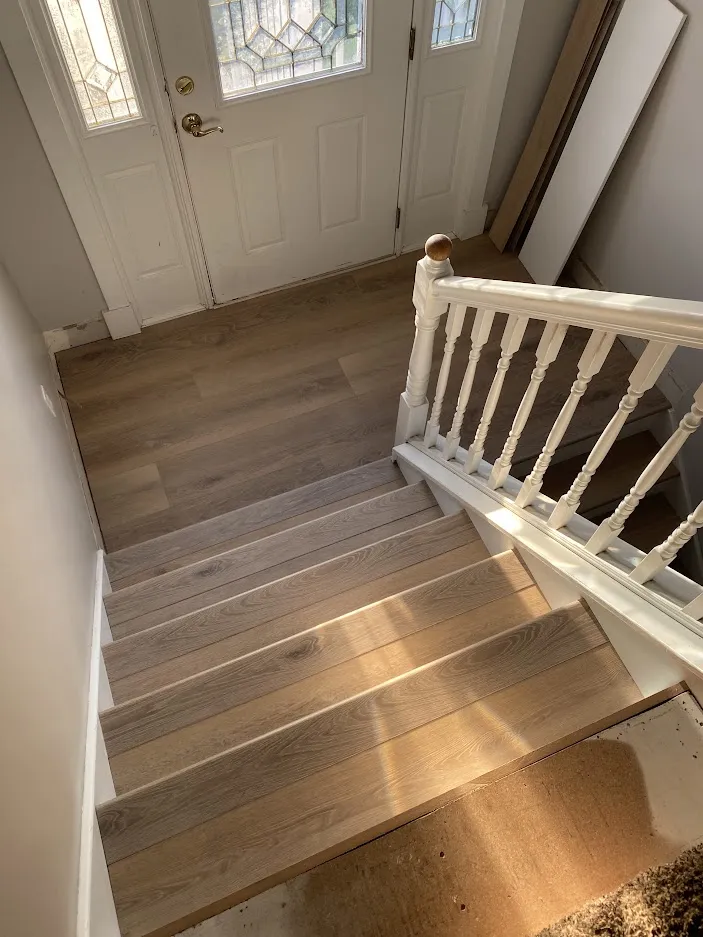 Stairs with new wood-look treads and a white spindle railing